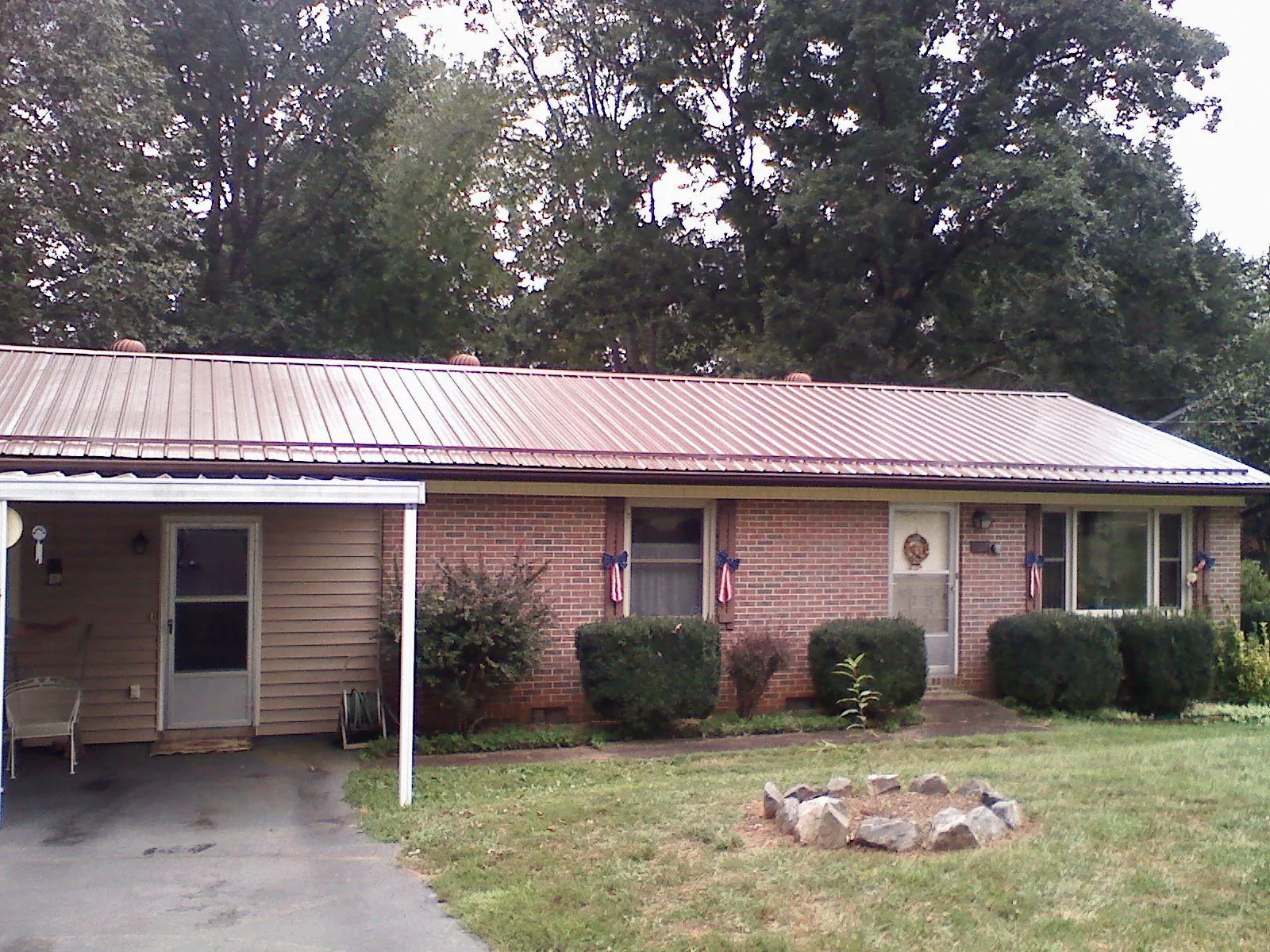 Bronze metal roof and carport on a brick ranch home — Roof Repair work by our crew in Merrimac